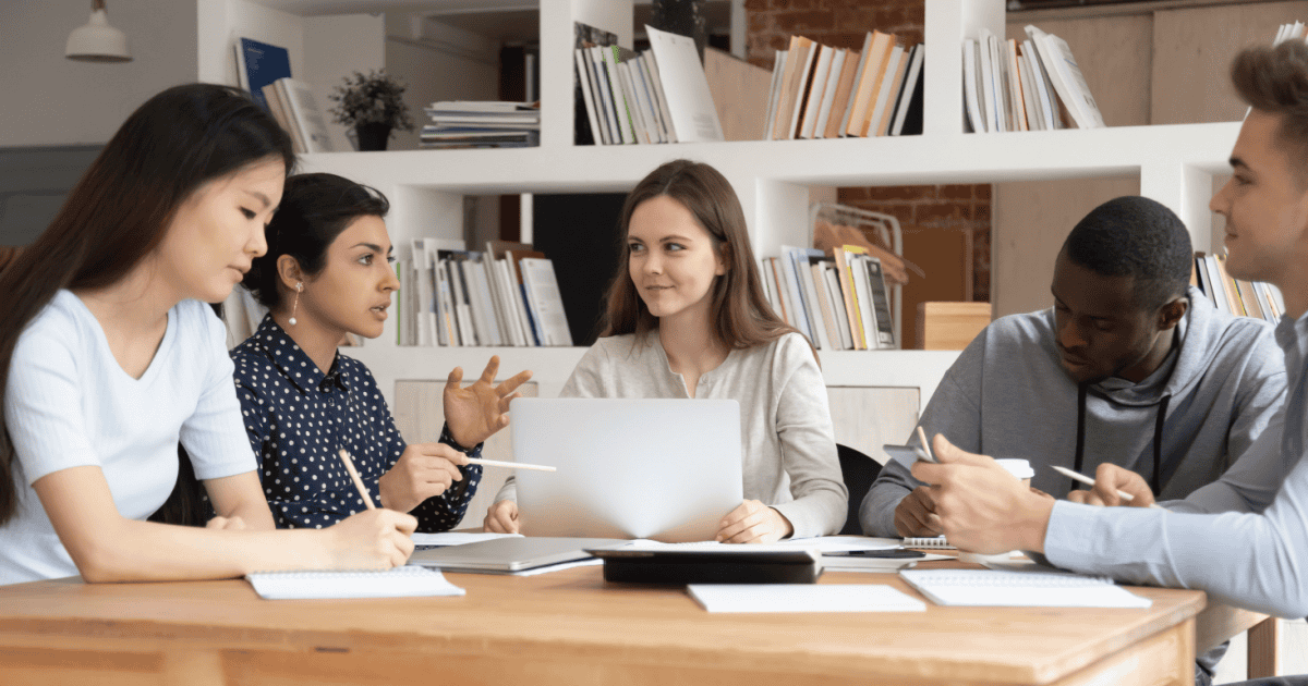 5 young people listen as one young woman shares her thoughts. This is a stock image and does not include those from the pilot project.